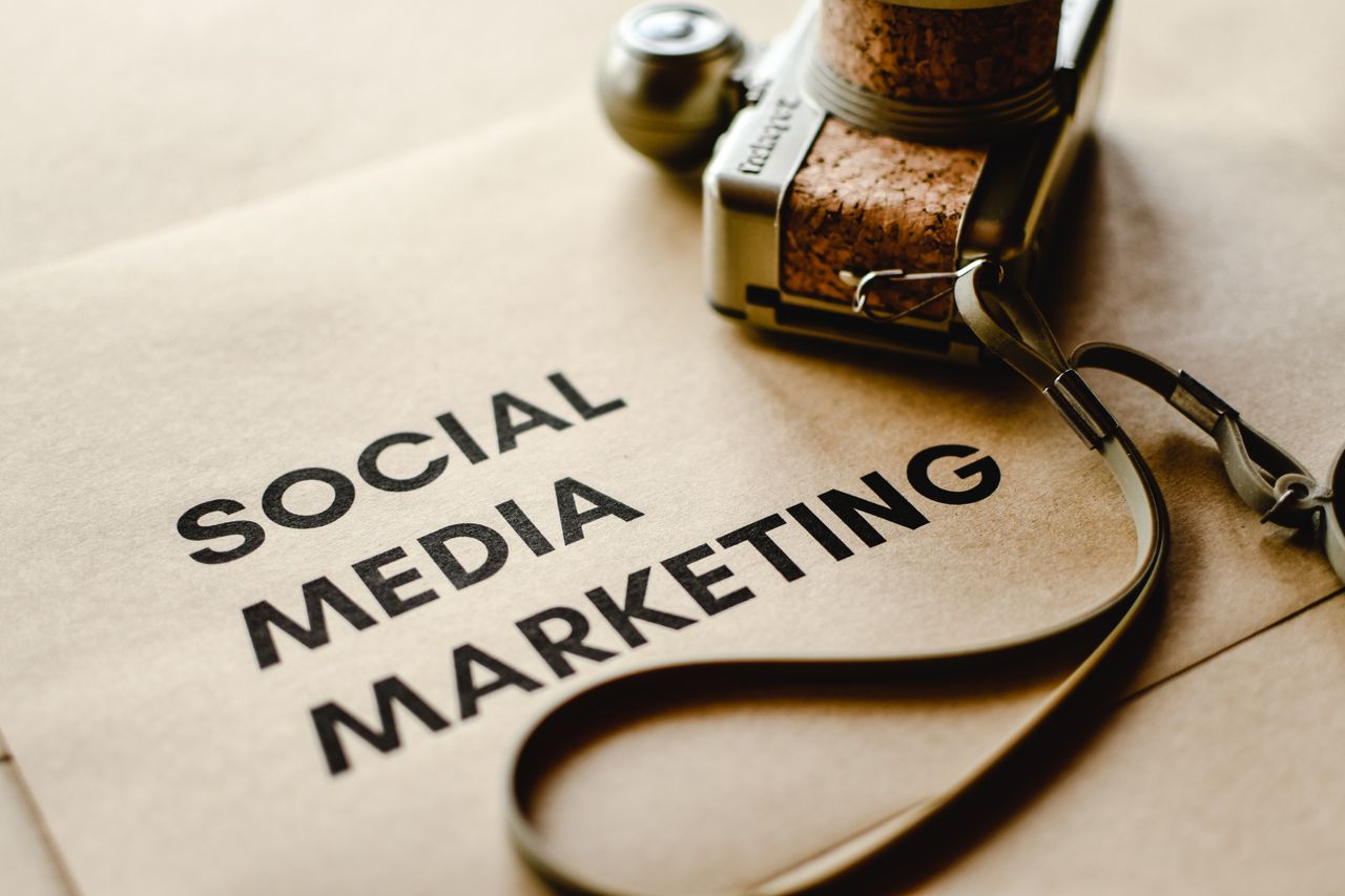 brand-02 Detailní záběr na fotoaparát položený na hnědém papíře s textem Social Media Marketing, který zdůrazňuje témata digitálního marketingu.